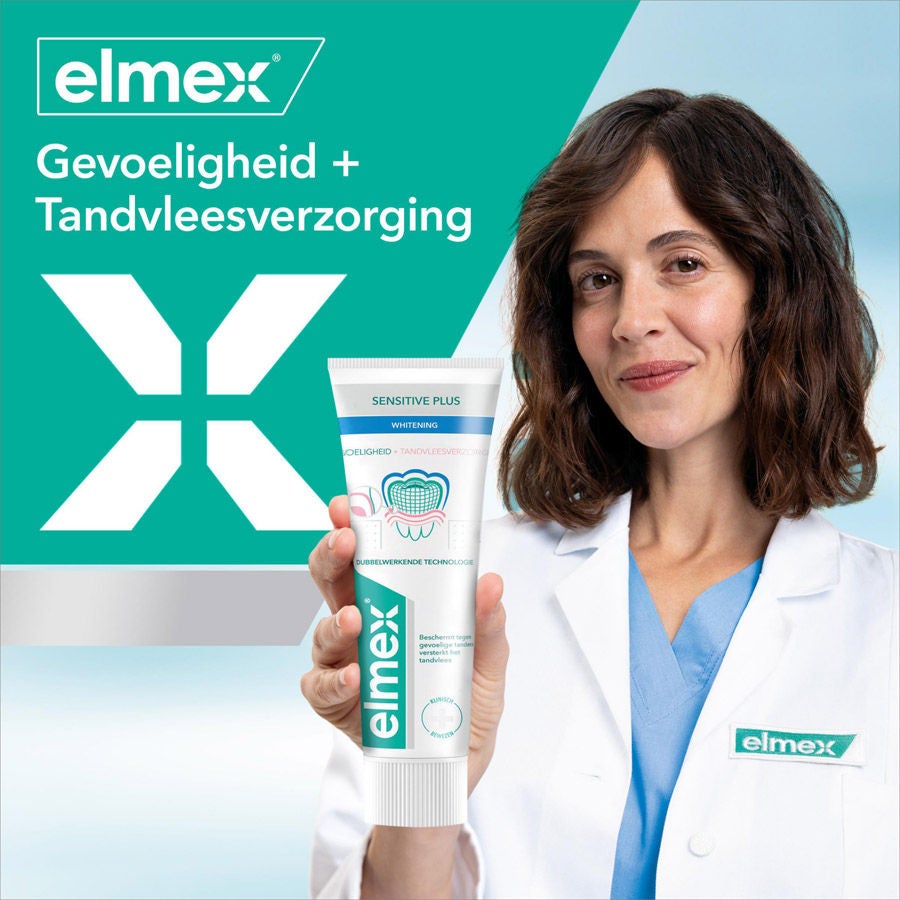 Tandarts houdt Elmex Sensitive Plus tandpasta vast voor gevoeligheid en tandvleesverzorging.