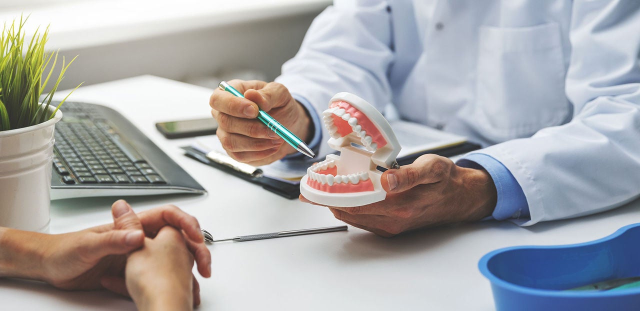 dentist and patient discussion about planned teeth treatment in dental clinic office